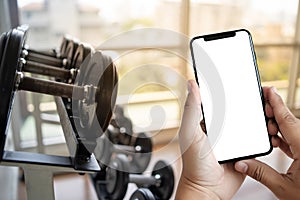 Young man Hand holding smartphone in gym to fitness phone fitne