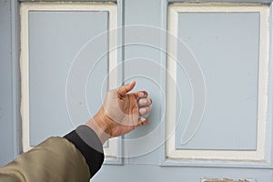 young man hand knocking door,