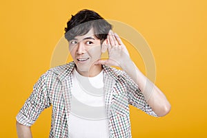 Young man  with hand over ear listening and hearing