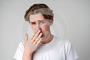 Young Man With Hand Over Mouth Showing Signs of Regret or Shock