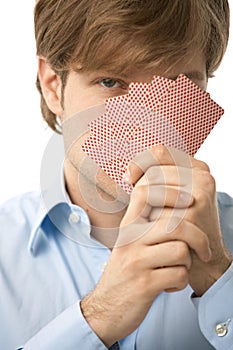 Young man with hand of playing cards