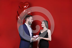 Young man handing a gift to his girlfriend.