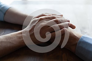 Young man hands covering wrinkled palms of mature old man