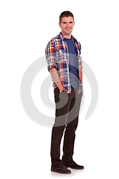 Young man with hands tucked in pockets photo