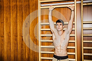 Young man hanging from gym equipment