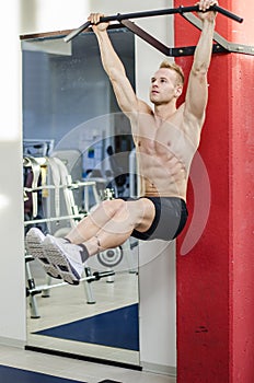 Young man hanging from gym equipment