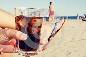 Young man hanging out on the beach with a cola drink