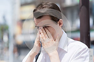 A young man has Itchy, watery, swollen eyes due to pollen allergy