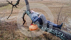 The young man has a rest, lying on a tree
