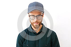 Young man with hat and glasses staring