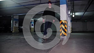 A young man in hat skateboarding inside the parking lot