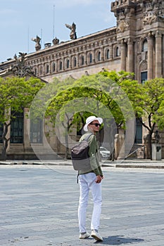 A young man in a hat, sunglasses walking in the port of Barcelon