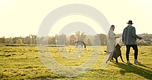 Young man in hat and young woman with dog in nature