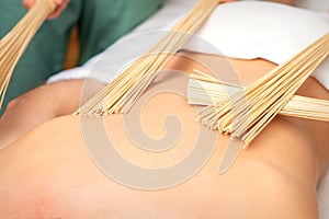 Young man have double samurai massage with bamboo brooms in spa. Relaxation massage concept.