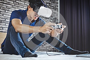 Young man have fun on bedroom in virtual reality headset or 3d g