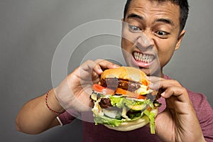 Young Man have a great desire to eat a burger