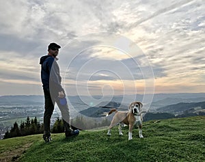 Young Man have a mountain dog walking with his beagle dog