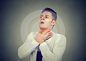 Young man having asthma attack or choking can`t breath suffering from respiration problems