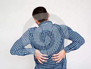 Young man having back pain. on white
