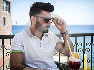 Young man having cocktail at outdoor bar