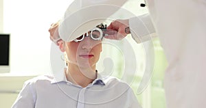 Young man is having eyes and vision checked by optometrist in clinic