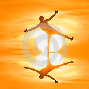 Young man having fun, standing on one leg, warm water sunset