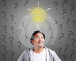 Young Man Having An Idea With Light Bulb Above His Head