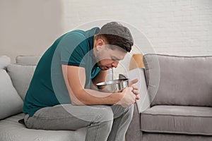 Young man having nausea at home