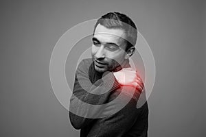 Young man having pain in his neck Black and white photo with red dot