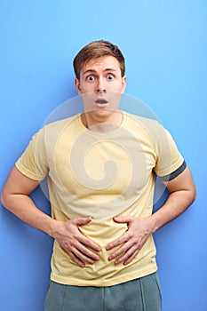young man having painful stomach ache, chronic gastritis or abdomen bloating