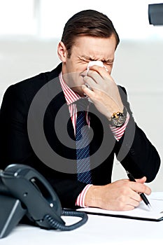 Young man having severe cold. Sneezing