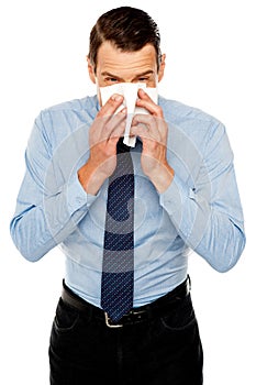 Young man having severe cold. Sneezing