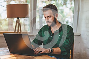Young man having sressful time working on laptop