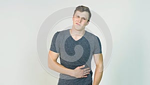 Young man having a stomachache on white background. Young man holds the stomach, it hurts