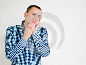 Young man having teeth pain. on white