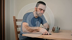 Young man having an urgent phone call in the middle of breakfast