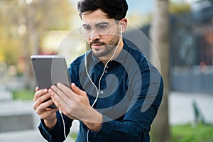 Young man having a video call on digital tablet outdoors.