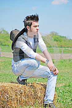 Young man on hay bale