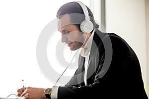 Young man in headphones learning foreign language