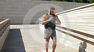 Young man in headphones running outdoors