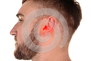 Young man with hearing problem on white background, closeup