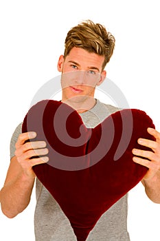 Young man with a heart shaped pillow