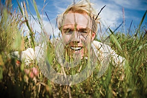 Young man hiding in the grass