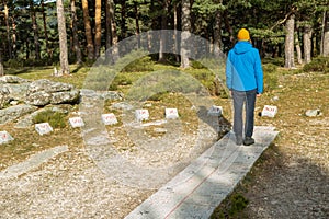 Young man hiker with stone sundial in the middle of the forest in Cercedilla, Madrid photo