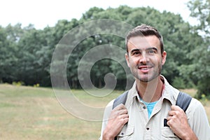 Young man hiking smiling happy portrait. Male hiker walking in forest