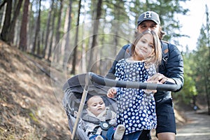 Young man with his adorable young daughters in the forest