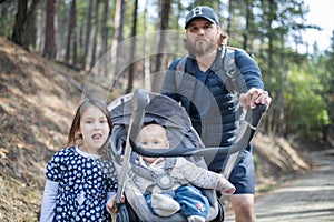 Young man with his adorable young daughters in the forest