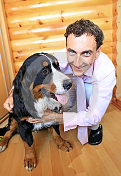 Young man with his bernese sennenhund dog