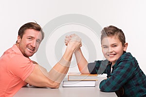 Young man and his son arm wrestling