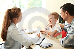 Young man and his son meeting with headmistress at school